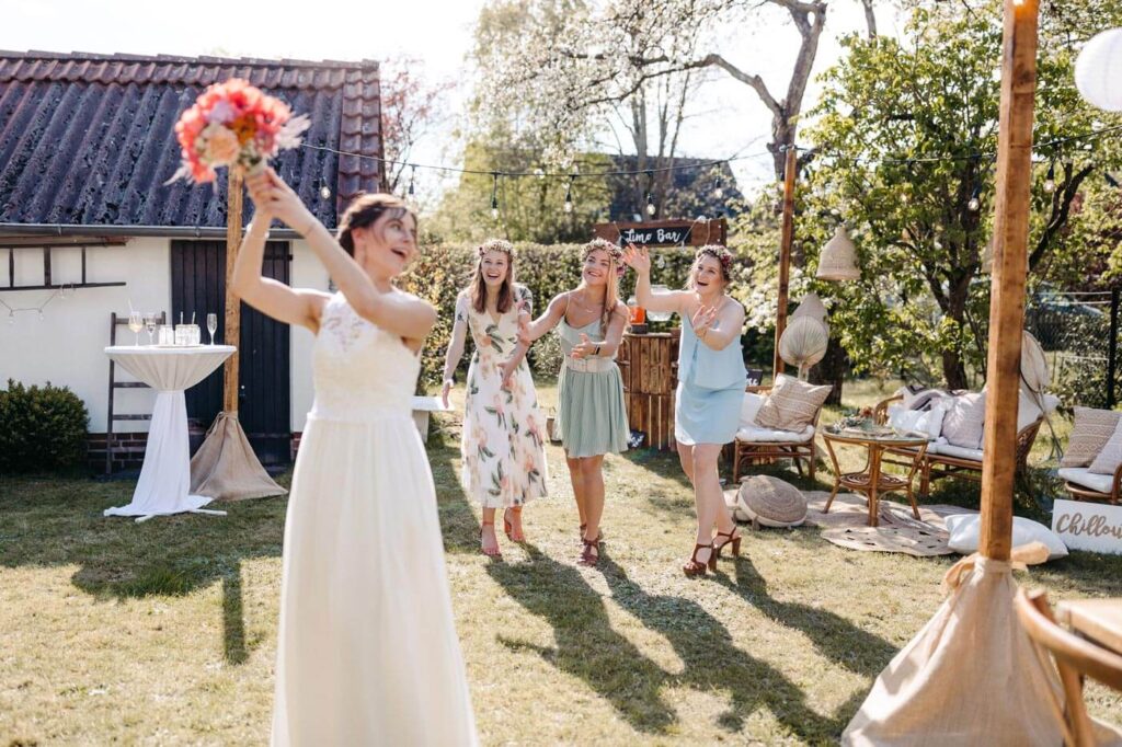 Braut wirft ihren Brautstrauss zu den Brautjungern