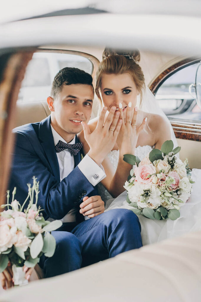 Hochzeitspaar zeigt Ihre Trauringe nach der Zeremonie