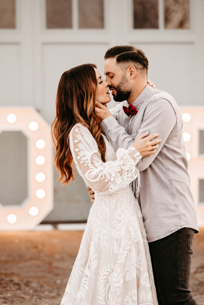 Brautpaar küsst sich vor LOVE Buchstaben