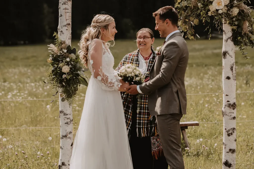 Glückliches Ehepaar bei der Trauzeremonie mit Traurednerin